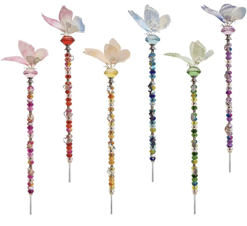 Six colorful beaded garden stakes with butterfly or flower designs on top, each featuring a unique DIY-inspired combination of vibrant colors and patterns.